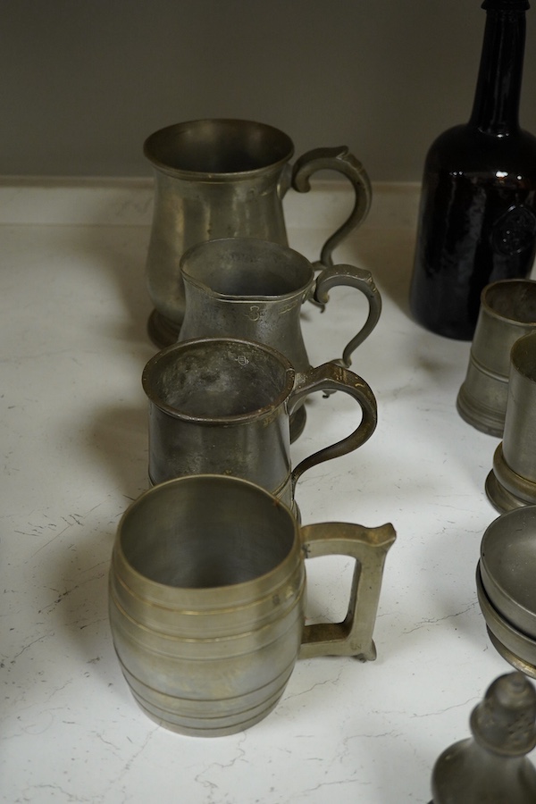 A collection of 18th and 19th century pewter mugs and other items including a 19th century wine bottle, bottle 27cm high. Condition - fair